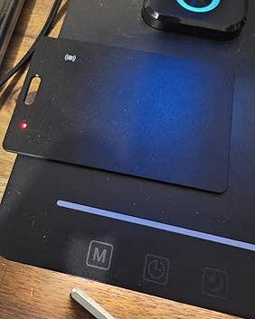 Black electronic device with blue light on a wooden surface